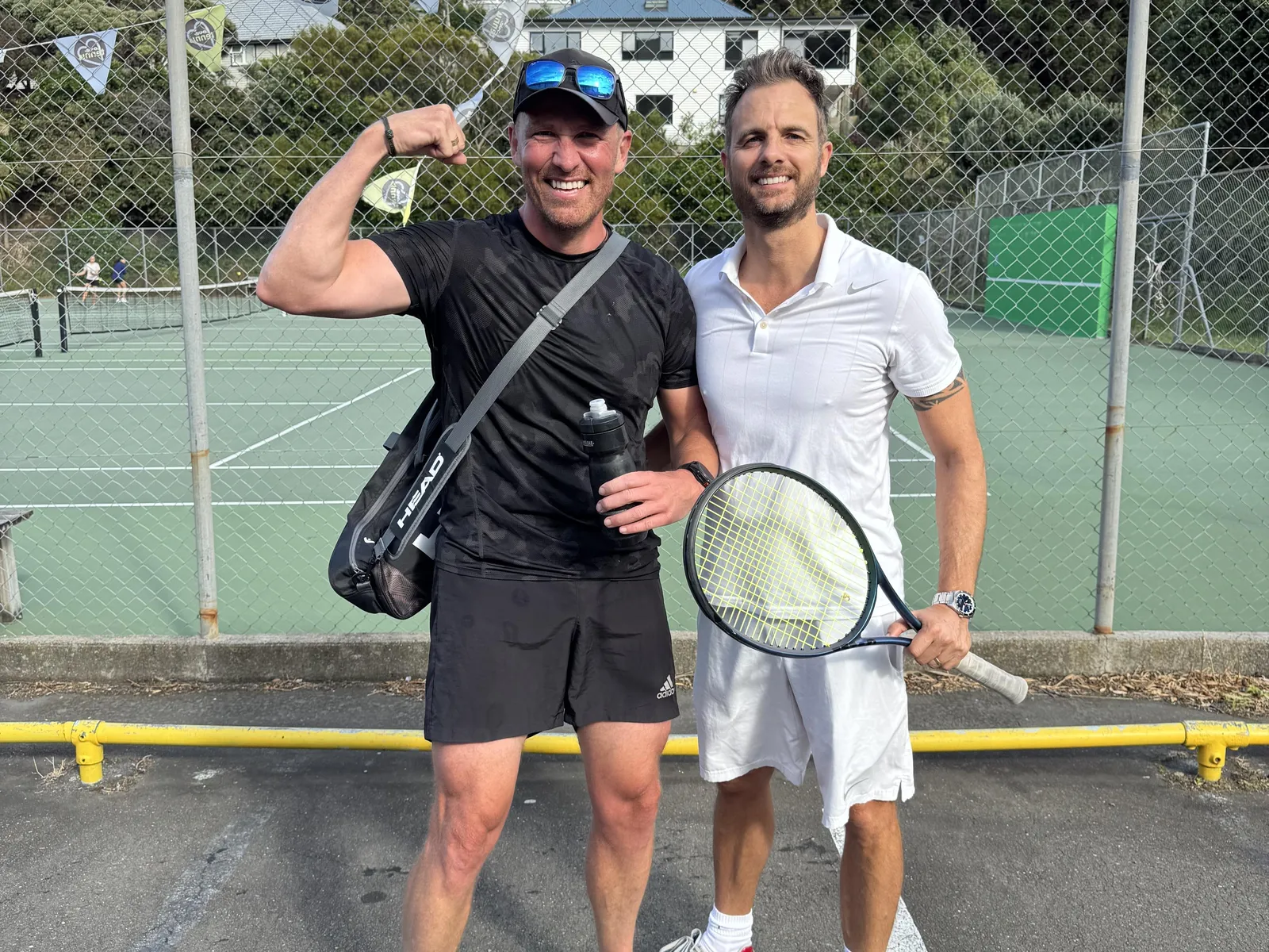 Trent and a friend posing with tennis rackets at a tennis club