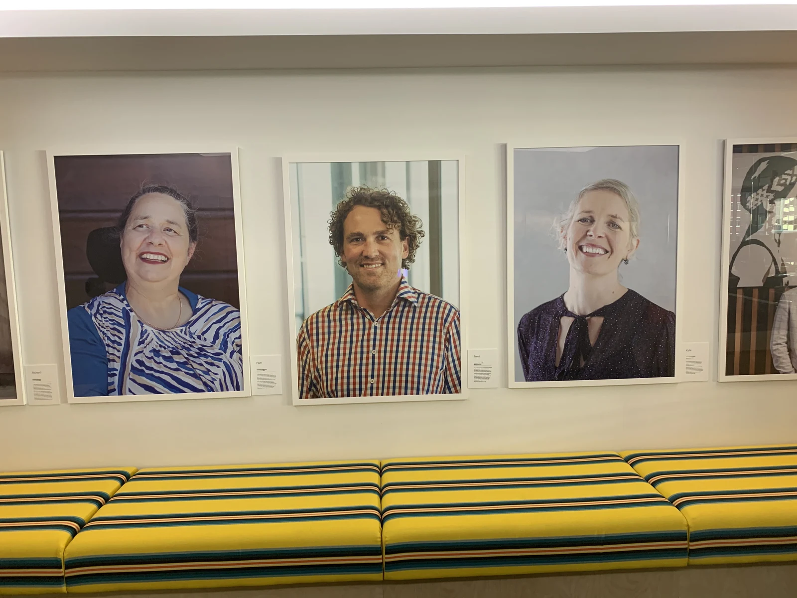 A wall of giant Customer Hero posters at Trade Me, including Trent's