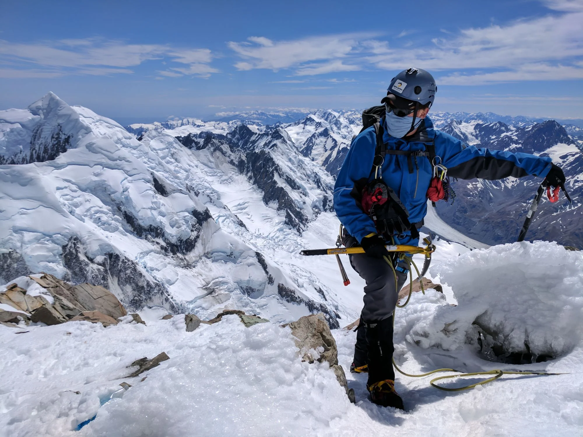 Trent in full mountaineering gear standing on the summit ridge of Aoraki/Mt Cook