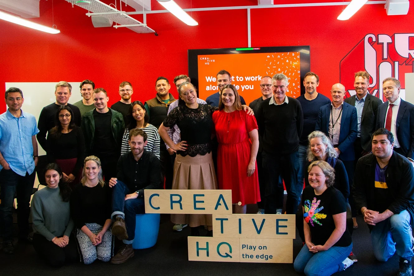 The Creative HQ team posing together in their red-walled office
