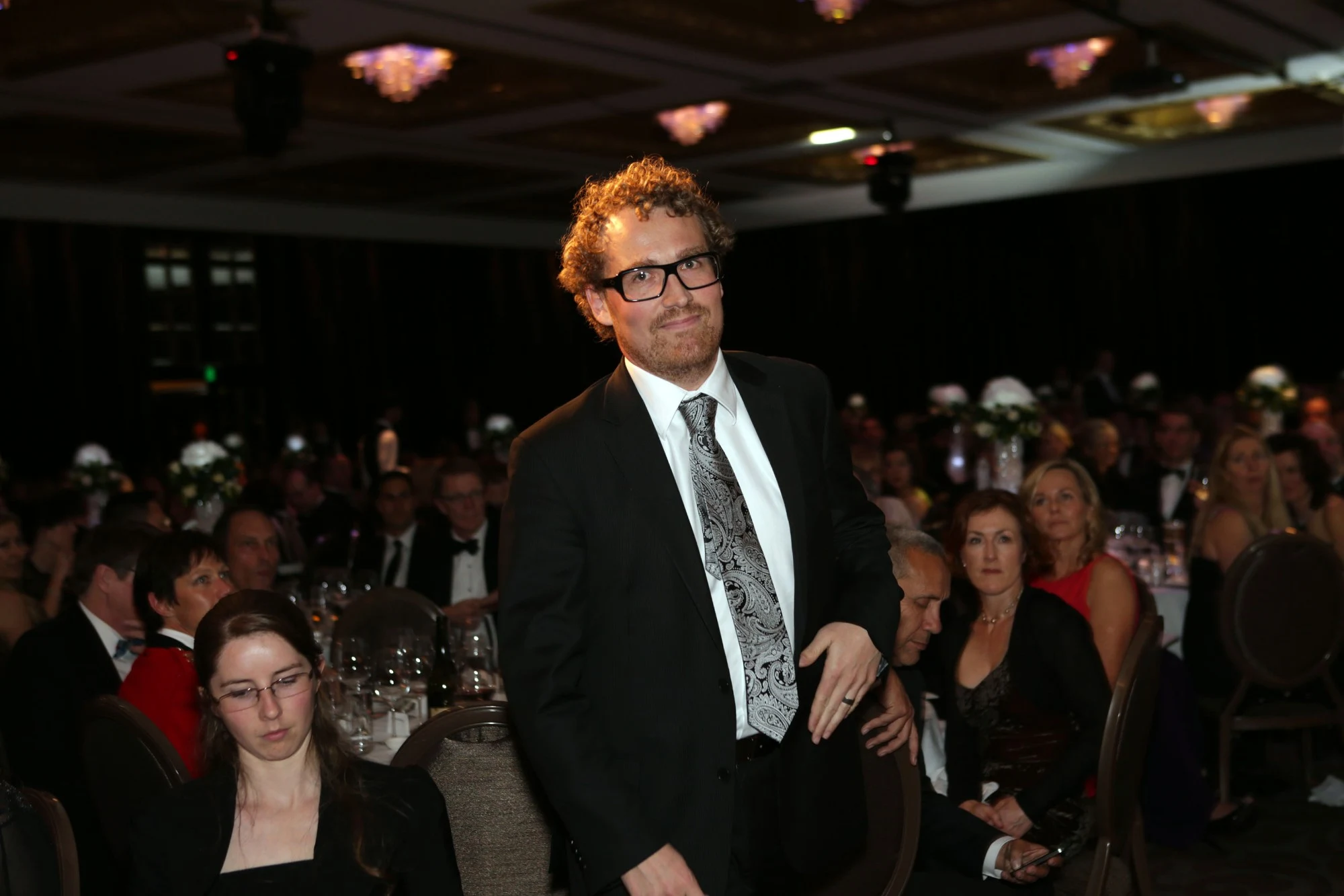 Trent in a suit and tie standing at a formal awards dinner