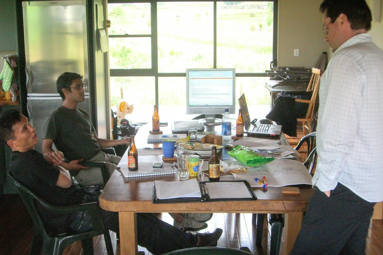 Sam Ng, Shailesh Manga and Richard Francis around a table at an offsite